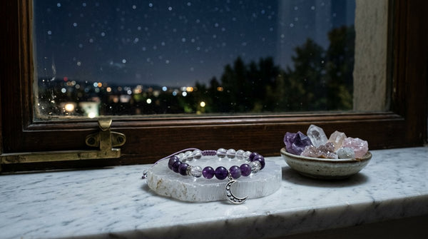 Crystal bracelet resting on a selenite plate in moonlight by a window
