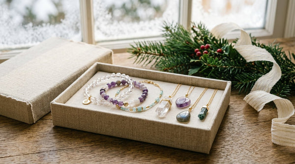 Crystal bracelets and gemstone pendants arranged in a holiday gift box