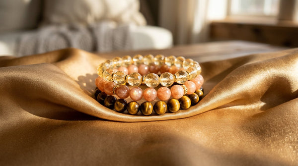 Crystal bracelet stack with citrine, sunstone, and tiger’s eye on golden fabric